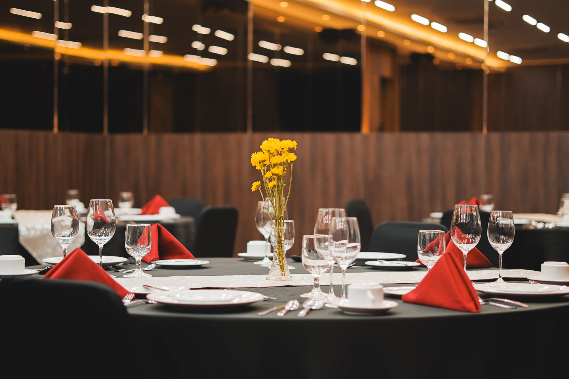 Round banquet tables with black cloths, red napkins and yellow flowers in the Omong-Omong meeting room